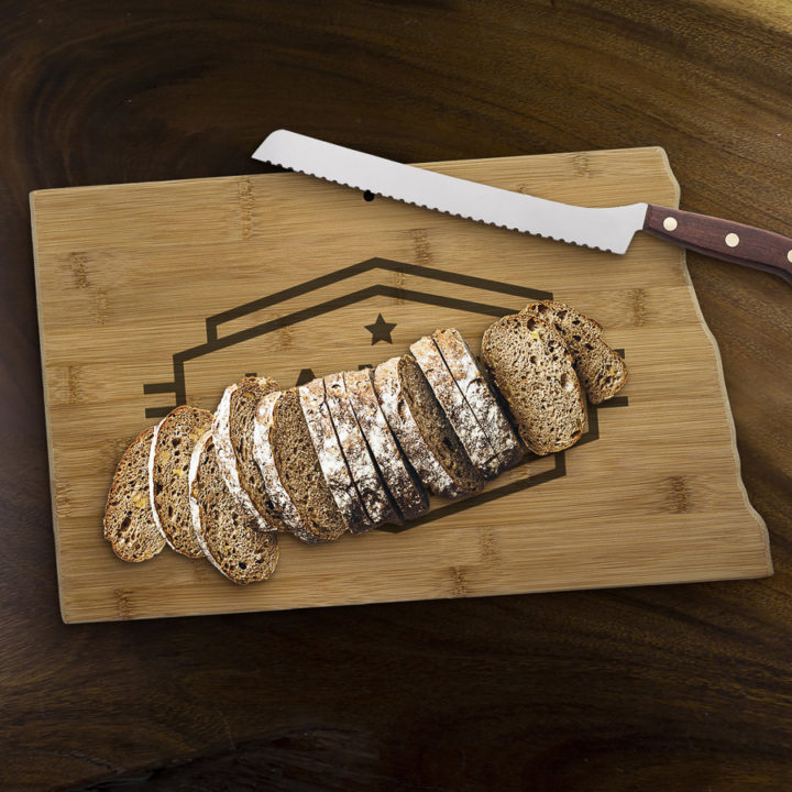 north dakota state shaped bamboo cutting board with personalized engraving on wood table besides red tomatoes