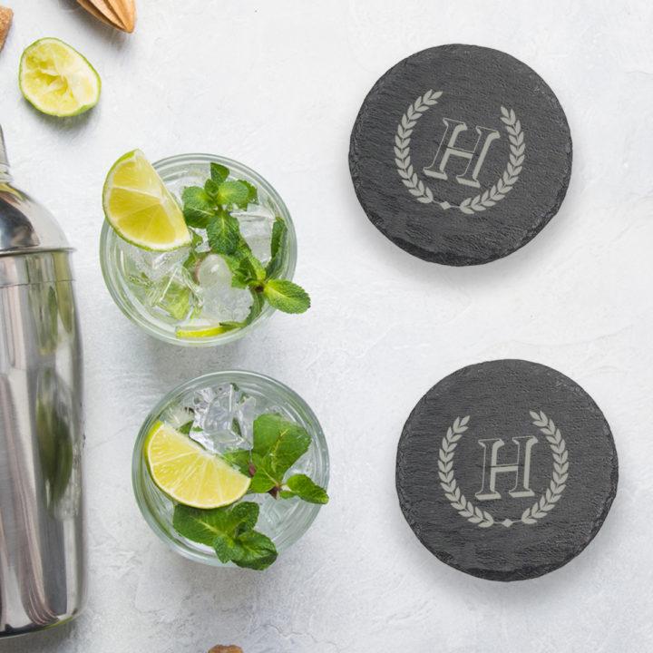 round slate coasters on top of table next to mojitos