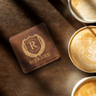 rustic leatherette coaster on table next to three cappuccinos