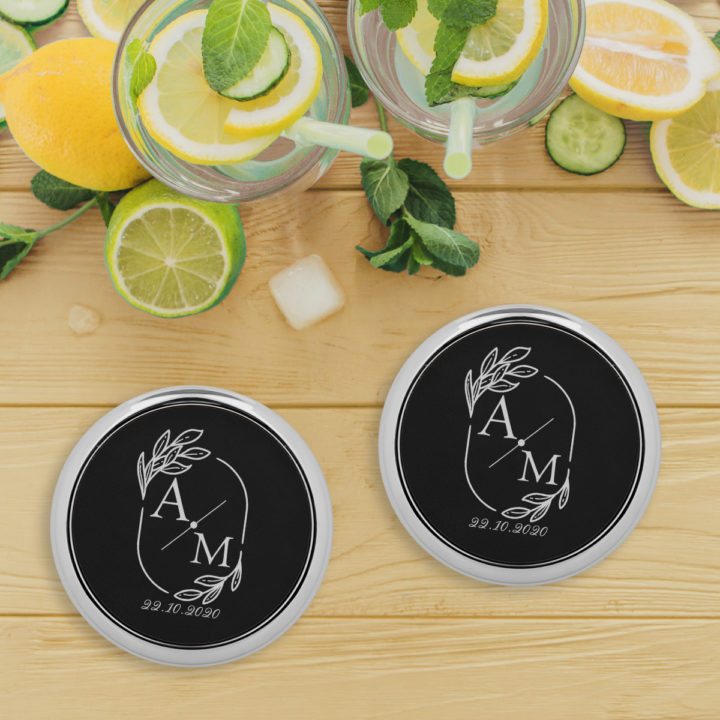 black leatherette coaster sets on top of wood table next to glasses of cold lemonade