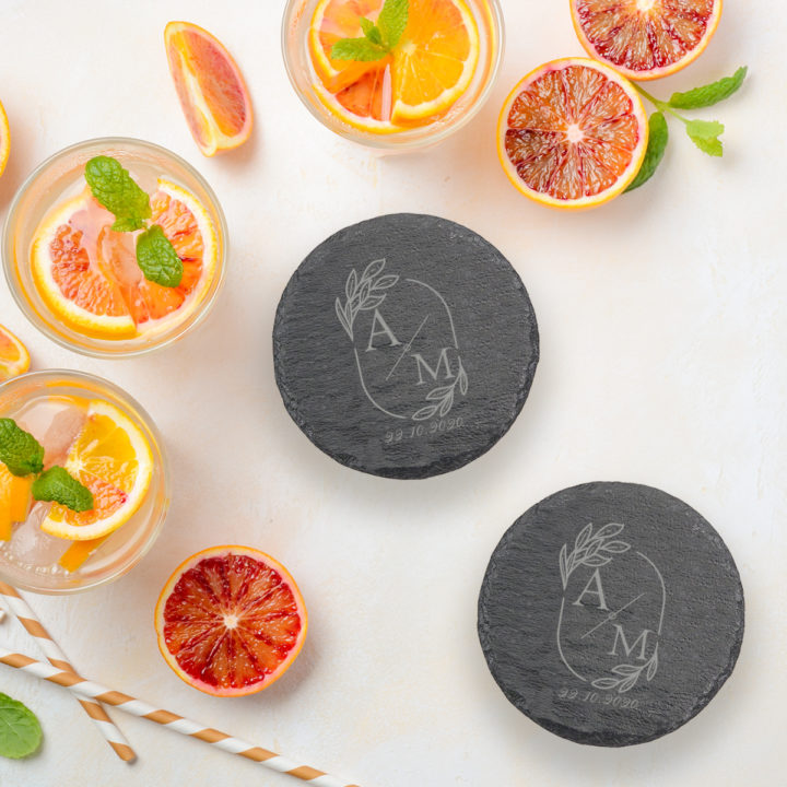 round slate coasters on top of table next to mixed drink