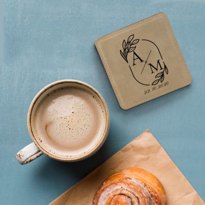 light blue leatherette coaster set on top of blue table next to cinnamon roll and cup of coffee