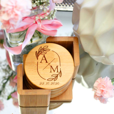 round bamboo coaster set on top of table next to wedding arrangements